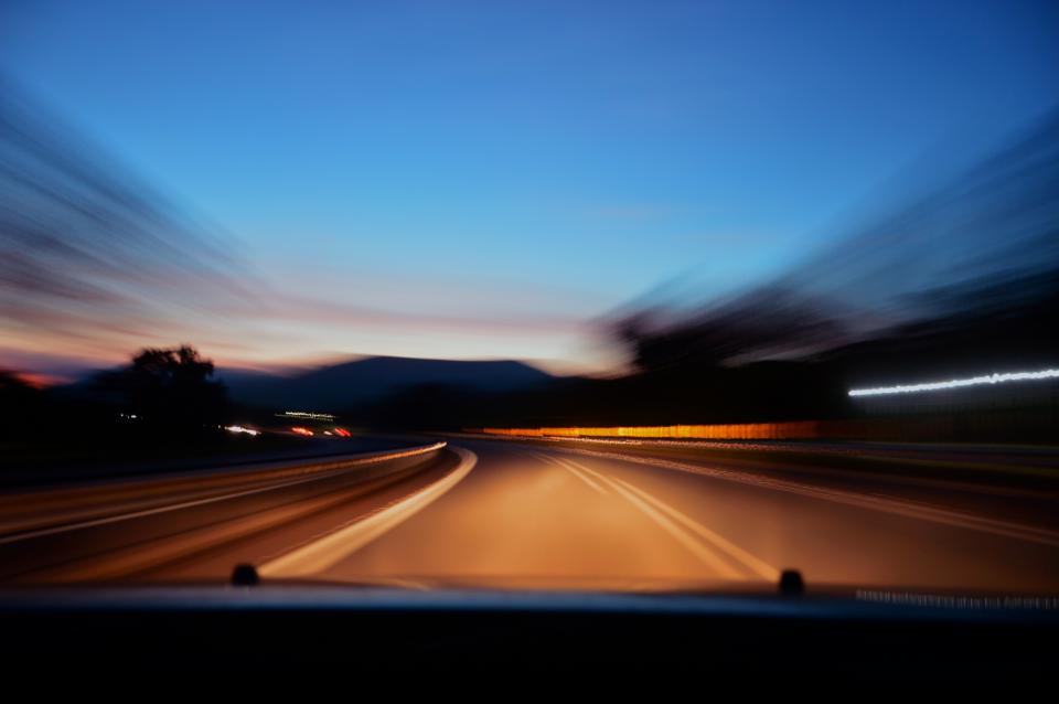 Landstraße in der Dämmerung aus dem fahrenden Auto